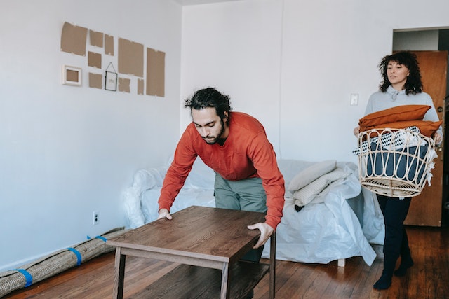 two people moving furniture